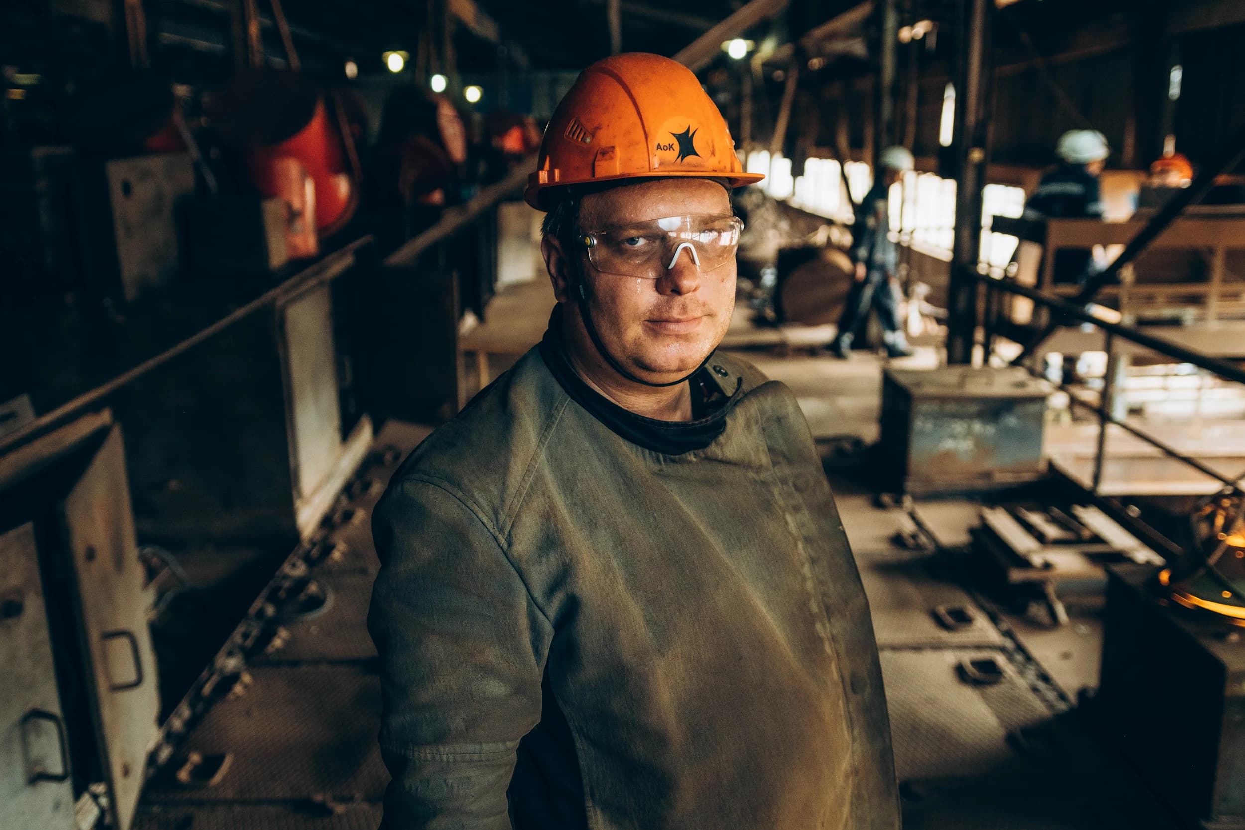 Foreman in an orange hard hat in an industrial hall